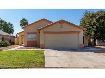 Inviting single-story home featuring a neutral stucco facade, two-car garage and well-maintained lawn at 15558 N 136Th Ln, Surprise, AZ 85374