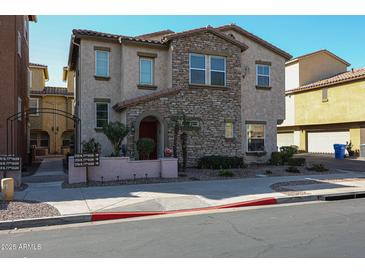 Charming two-story home with a stone facade, front patio and manicured landscaping at 1722 N 77Th Gln, Phoenix, AZ 85035