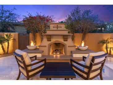 Inviting outdoor fireplace with chairs, creating a cozy ambiance for relaxing evenings at 20750 N 87Th St # 1137, Scottsdale, AZ 85255