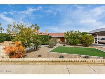 Charming single-story home featuring mature landscaping, a red tile roof, and a well-manicured front yard at 212 W Interlacken Dr, Phoenix, AZ 85023