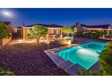 Backyard view of a refreshing pool, stone patio and desert landscaping at 23236 N Caleta Ct, Sun City West, AZ 85375