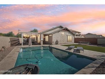 Beautiful backyard pool with lounge chairs and a covered patio, perfect for relaxing and entertaining guests at 30480 N 128Th Ln, Peoria, AZ 85383