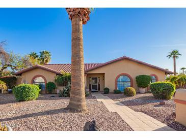 Charming single-story home features a tile roof, arched windows, and a beautifully xeriscaped front yard with mature landscaping at 315 W Sonoma Dr, Litchfield Park, AZ 85340