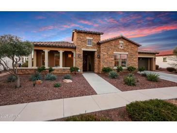 Charming stone home with manicured landscaping and covered front porch at 4820 N 210Th Ave, Buckeye, AZ 85396