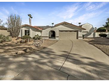 Stunning single-story home boasting manicured desert landscaping and a spacious driveway at 5432 E Juniper Ave, Scottsdale, AZ 85254