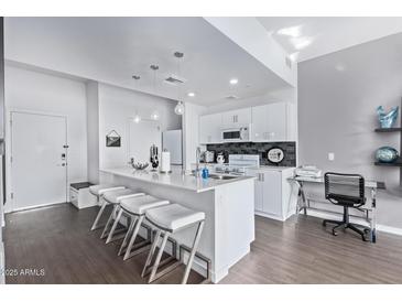 Modern kitchen features a large island with seating, white cabinets, and stainless steel appliances at 1130 N 2Nd St # 411, Phoenix, AZ 85004