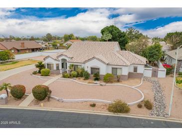 A stunning single-story home with a well-manicured front yard, circular driveway, and a neutral color palette at 1349 E Anasazi St, Mesa, AZ 85203