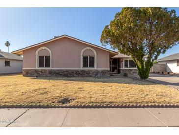 Charming single-story home with a stone accent facade and mature desert landscaping at 14408 N 35Th Ave, Phoenix, AZ 85053