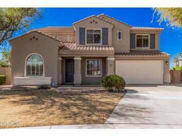 Charming two-story home featuring a well-manicured lawn and an attached two-car garage at 1481 E Lark St, Gilbert, AZ 85297