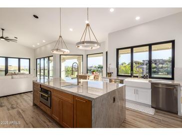 Bright kitchen featuring a large island with granite countertop, modern lighting, and stainless steel appliances at 15747 E Greystone Dr, Fountain Hills, AZ 85268