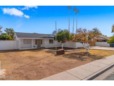 Traditional single-story home with a xeriscaped front yard and a white picket fence at 1743 N Dresden --, Mesa, AZ 85203