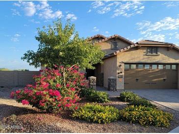 Charming single-story home with a landscaped front yard, colorful shrubbery and attached two-car garage at 17530 W Oberlin Way, Surprise, AZ 85387