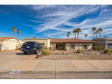 Charming single-story home featuring a tile roof, desert landscaping, and a welcoming front entrance at 1908 E Beck Ln, Phoenix, AZ 85022