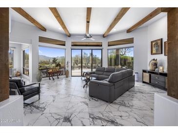 Bright living room boasts marble floors, exposed beam ceiling, and oversized windows with mountain views at 19131 E Tonto Verde Dr, Rio Verde, AZ 85263