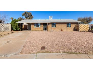 Charming single-story brick home with a low-maintenance, rockscaped front yard and a covered carport at 8612 N 31St Ln, Phoenix, AZ 85051