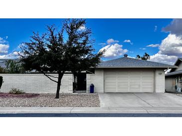 Charming single-story home featuring a well-manicured lawn, two-car garage, and inviting curb appeal at 12810 W Ashwood Dr, Sun City West, AZ 85375