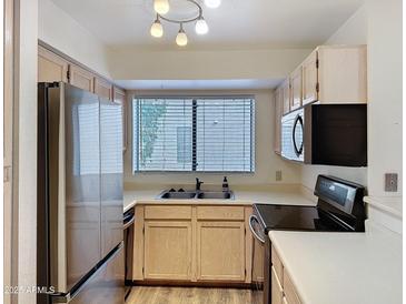 Bright kitchen featuring stainless steel appliances and a window over the sink at 19820 N 13Th Ave # 241, Phoenix, AZ 85027