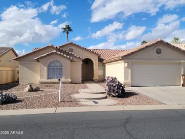 Charming single-story home with a tile roof, desert landscaping, and an attached two-car garage at 24214 S Briar Wing Dr, Sun Lakes, AZ 85248