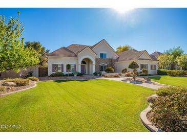 Charming single-story home featuring a well-manicured lawn, lush landscaping, and a welcoming entryway at 2467 E Page Ave, Gilbert, AZ 85234