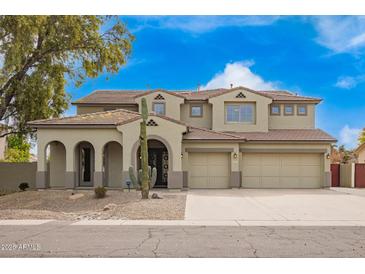 Inviting two-story home featuring a three-car garage and desert landscaping, creating curb appeal at 2873 E Nolan Pl, Chandler, AZ 85249