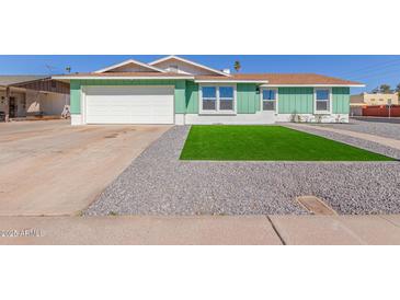 Charming single-Gathering home with a two-car garage, green grass and rock landscaping at 3102 W Desert Cove Ave, Phoenix, AZ 85029