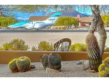 Desert home featuring a private jet on the tarmac in front of cactus landscaping at 8502 E Cave Creek Rd # 10, Carefree, AZ 85377