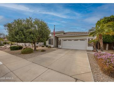 Charming single-story home with a well-manicured lawn, concrete driveway, and a two-car garage at 9213 W Clara Ln, Peoria, AZ 85382