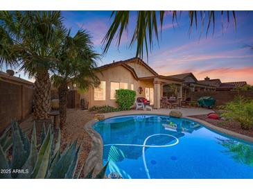 Inviting backyard pool with lush tropical landscaping, patio seating, and a tranquil desert vibe perfect for relaxing at 9796 E Stone Cir Ln, Gold Canyon, AZ 85118