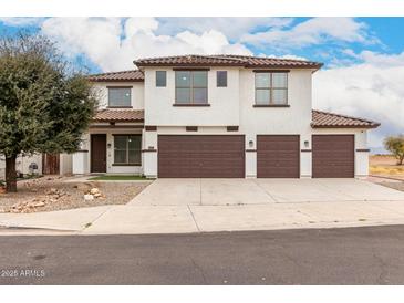 Two-story home featuring a three-car garage, tile roof, and modern design at 20358 N Valencia N Dr, Maricopa, AZ 85138