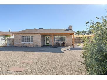 Charming single-story home with a stone facade, covered porch, and desert landscaping at 541 W Edgemont Ave, Phoenix, AZ 85003
