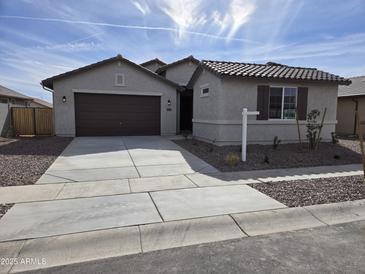 Charming single-story home with a well-manicured front yard and a two-car garage at 1187 E Ridgerock St, Casa Grande, AZ 85122