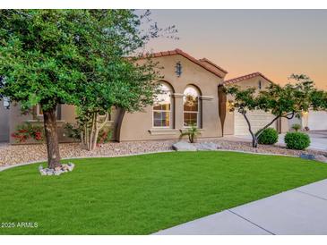 Charming home with a well-manicured lawn, desert landscaping, and beautiful, arched windows at 15829 W Bonitos Dr, Goodyear, AZ 85395