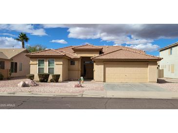 Charming single-story home featuring a well-manicured yard, a two-car garage, and a classic tile roof at 16132 W Ironwood St, Surprise, AZ 85374