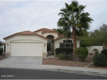 Charming single-story home featuring desert landscaping, a two car garage and a welcoming front entrance at 1870 N 128Th Dr, Avondale, AZ 85392