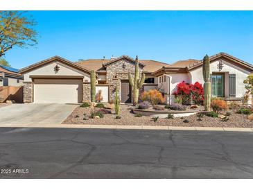 Charming single-story home with desert landscaping and stone accents on a sunny day at 1918 W Medinah Ct, Anthem, AZ 85086