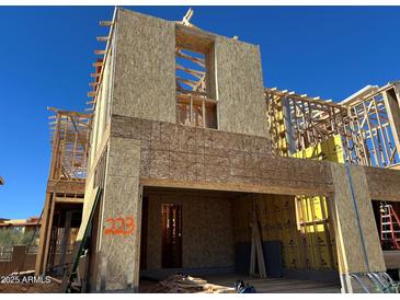 New construction home showcasing the framing and structure under a clear blue sky at 21208 N 58Th St, Phoenix, AZ 85054