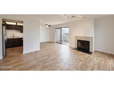 Bright living room featuring tile floors, fireplace and sliding glass doors to private patio at 2959 N 68Th Pl # 112, Scottsdale, AZ 85251