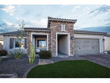 Charming exterior with stone accents, turf yard and desert landscaping at 19139 N 260Th Ave, Buckeye, AZ 85396
