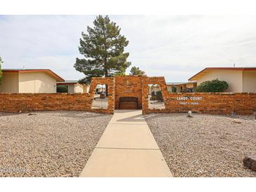 Inviting community entrance featuring a decorative brick wall and bench seating for residents at 13251 W Aleppo Dr, Sun City West, AZ 85375