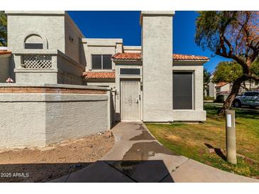 Charming townhome featuring a well-maintained stucco exterior, red roof tiles, and a secure front entry gate at 1717 E Union Hills Dr # 1065, Phoenix, AZ 85024