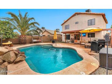 Inviting backyard pool with patio, BBQ, palm tree, and covered seating area perfect for outdoor entertaining at 22412 N 20Th Pl, Phoenix, AZ 85024