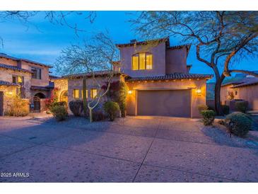 Charming two-story stucco home featuring a two-car garage and a tile roof at twilight at 7442 E Golden Eagle Cir, Gold Canyon, AZ 85118