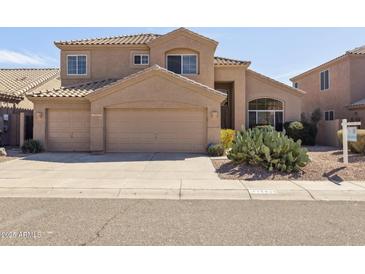 Warm, tan two-story home featuring a tile roof, a three-car garage, and desert landscaping at 15825 S 1St Ave, Phoenix, AZ 85045