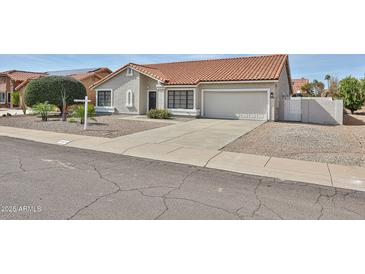 Charming single-story home featuring a well-manicured front yard and two car garage at 19824 N 94Th Ln, Peoria, AZ 85382