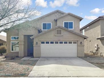 Charming two-story home with a two-car garage and manicured front lawn under a beautiful blue sky at 44361 W Mcclelland Dr, Maricopa, AZ 85138