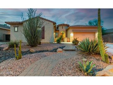 Inviting home featuring desert landscaping, a winding brick path, and a two-car garage at 9295 W Quail Track Dr, Peoria, AZ 85383