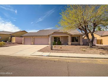 Charming single-story home featuring a three-car garage, well-kept landscaping and desert-friendly yard at 11222 S Hopi Dr, Goodyear, AZ 85338