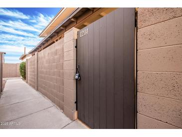 Gated side yard features block wall with walkway, desert landscaping, and address marker at 1214 N 84Th Pl, Scottsdale, AZ 85257