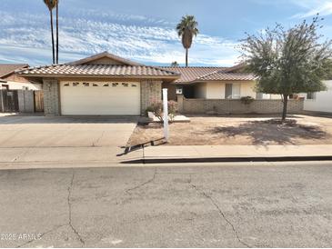 Charming single-story home with a well-maintained front yard and a two-car garage at 1455 W Posada Ave, Mesa, AZ 85202