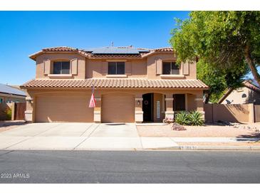 Two-story home featuring a tile roof, three-car garage, manicured landscaping and solar panels at 16626 W Baden Ave, Goodyear, AZ 85338